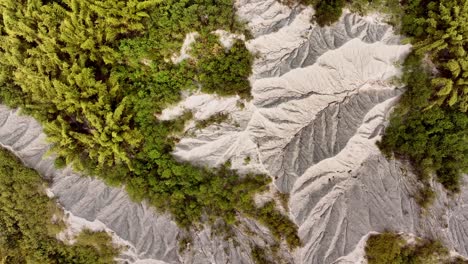 Aerial-flyover-beautiful-badlands-mud-volcano-landscape-with-vegetation-in-Taiwan