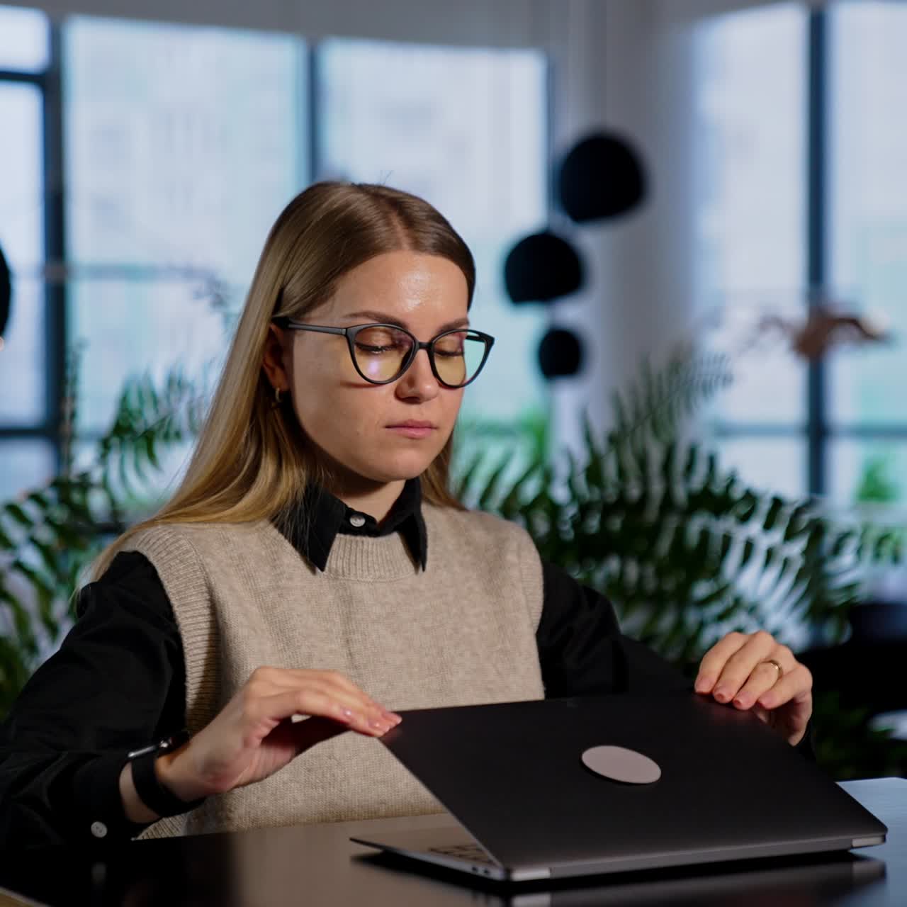 Calm pretty woman wearing glasses sits in front of laptop. Lady closes her notebook and takes off her glasses massaging nose bridge