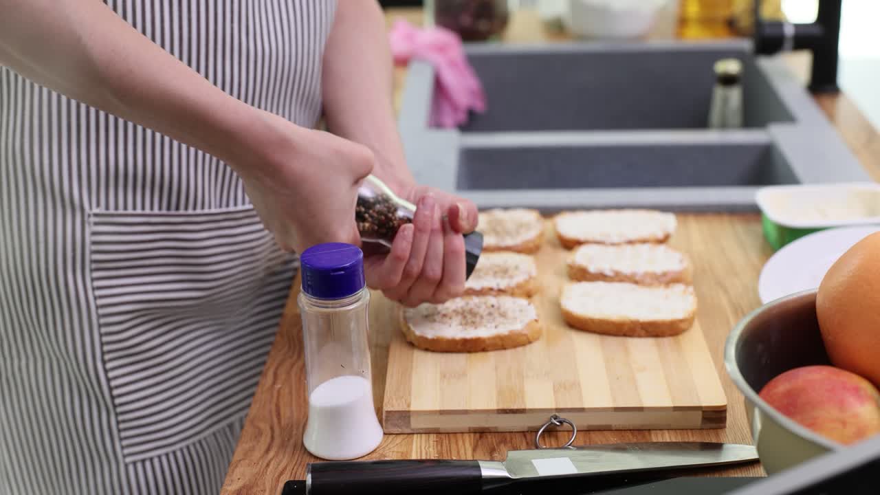 Housewife sprinkles fragrant spices over slices of bread