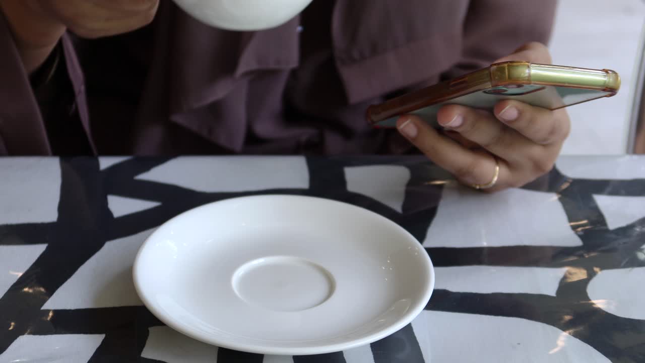 Women drinking coffee and using smart phone on table