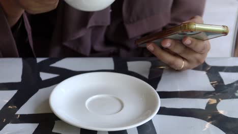 Women-drinking-coffee-and-using-smart-phone-on-table