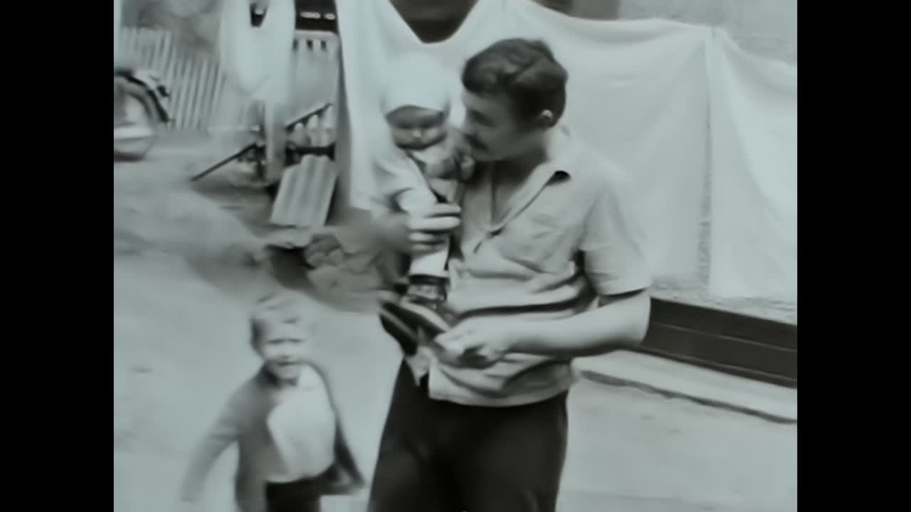 Soviet Man Holding Baby, A Touching Video Portraying Parenthood in the USSR Archive. CIRCA USSR 1980s: A heartwarming video capturing a Soviet man embracing a baby, showcasing the strong bond of family in the Soviet Union.