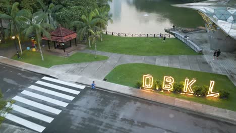 beautiful tilt up shot, starting in a lakeview, then a beautiful skyline city view appears in-between a botanical garden