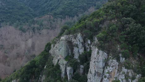 Orbit-motion-shot-demonstrating-a-cliff-on-a-mountain-in-Sithonia,-Chalkidiki,-Greece