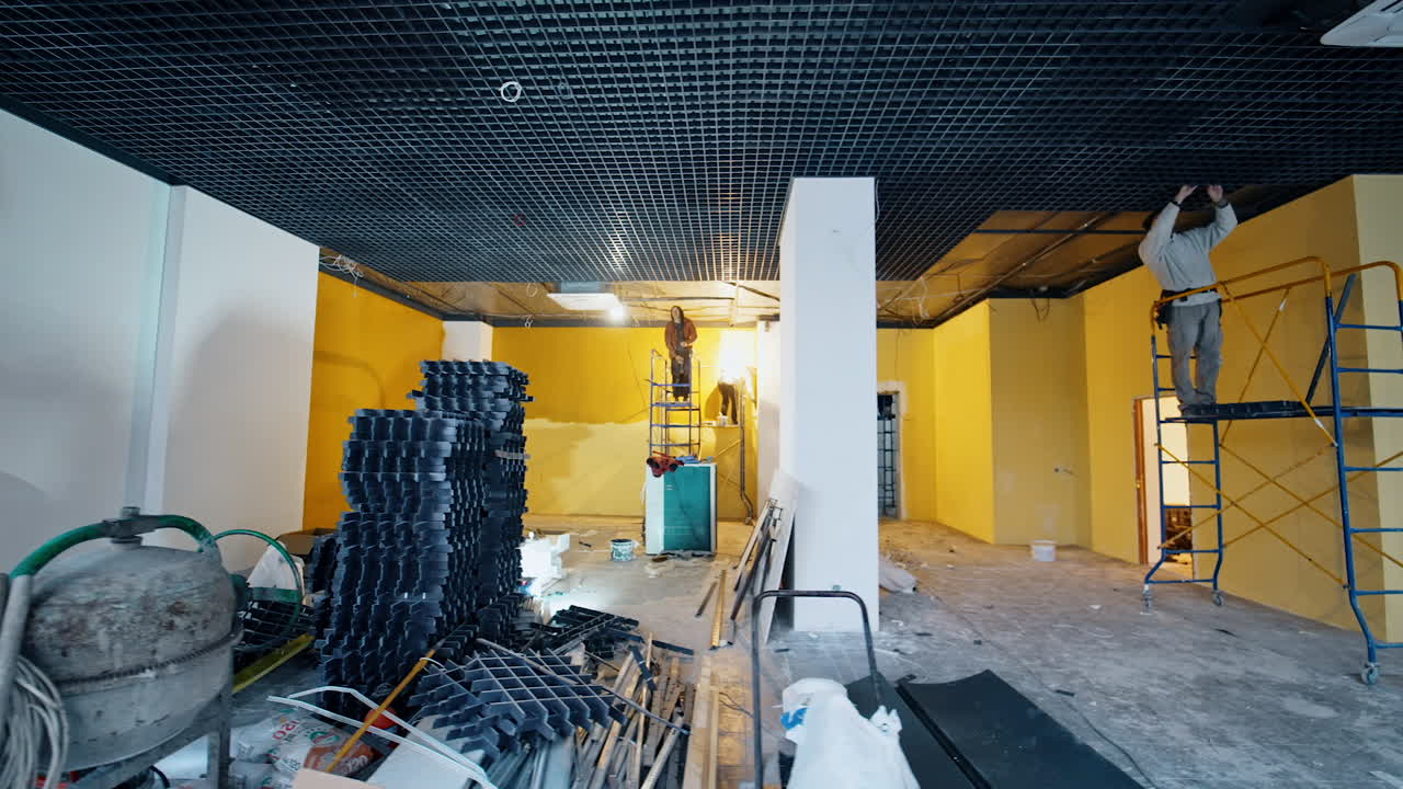 Unfinished premise with building and repairing works in progress. Spacious room with materials and equipment in the middle.