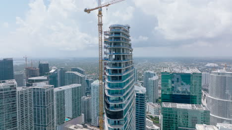 Hoher-Turmkran,-Der-Auf-Wolkenkratzerbaustelle-Arbeitet.-Luftaufnahme-Von-Geschäfts--Oder-Wohntürmen.-Miami,-USA