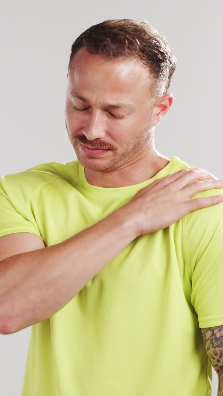 Homem Esfregando o Ombro Devido à Dor e Desconforto