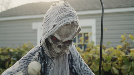 A-skeleton-in-a-hoodie-stands-near-the-house.-Halloween-decorations