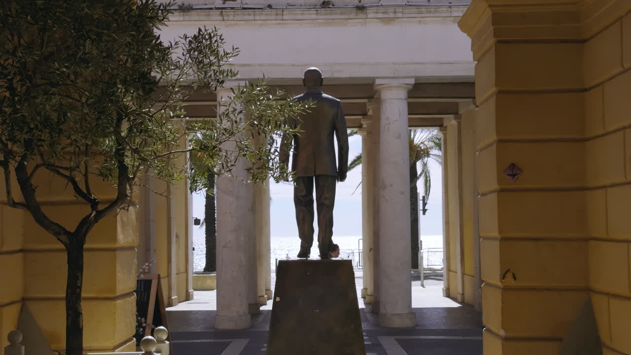 Bronze Statue of a Man in a Colonnaded Public Space with Sea View