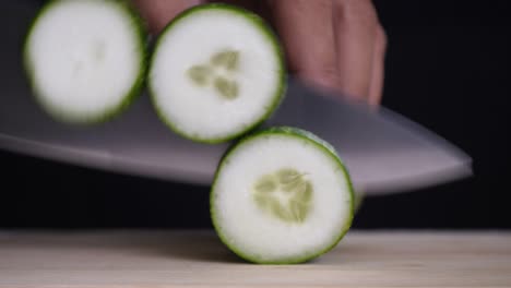 chef slices cucumber for cooking