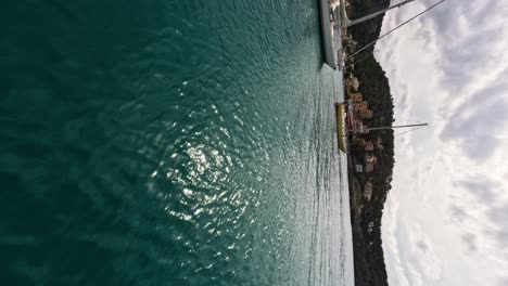 vertical fpv drone fly over turquoise water bay with sailing boats, mallorca