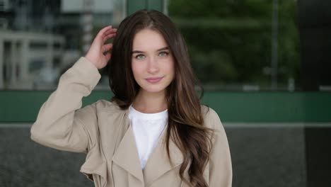 caucasian girl looking at camera, smiling, correcting hair