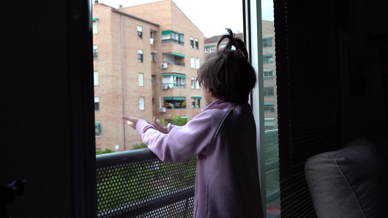 Ragazza che applaude alla finestra a sostegno delle persone contro il coronavirus.