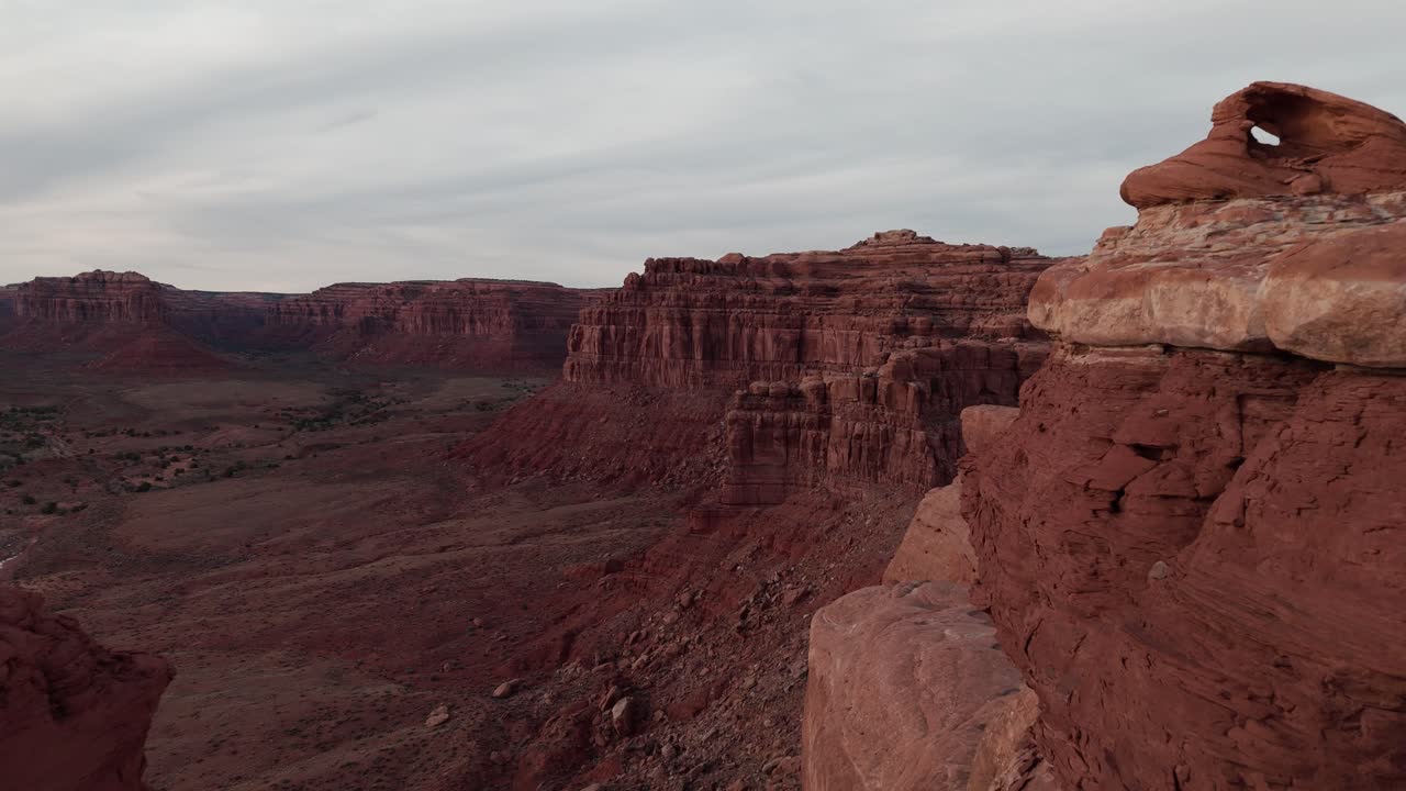 Drone che si fa strada tra due massi per rivelare una grande valle nello Utah meridionale alla luce del pomeriggio