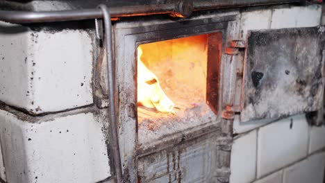 man opens a door in a rustic old kitchen stove