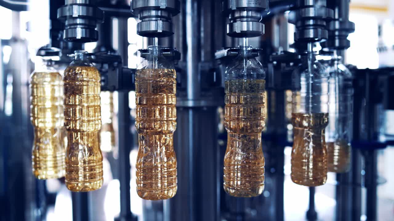Olivenöl wird in Plastikflaschen abgefüllt. Prozess der Sonnenblumenölproduktion in der Fabrik. Speiseölflaschen bewegen sich auf einem Rundförderband
