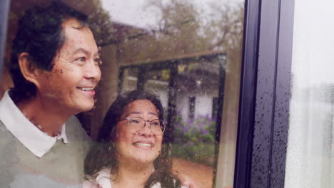 mature couple enjoying the view of winter rain