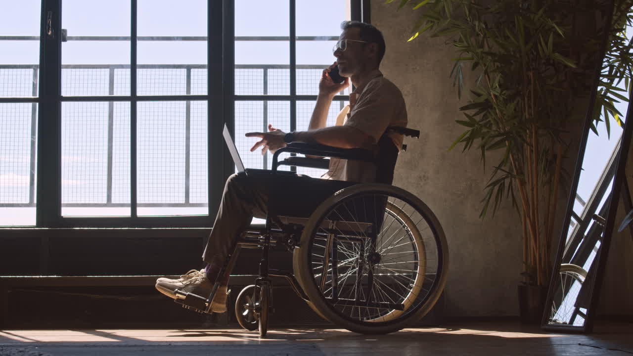 Man in Wheelchair Talking on Phone