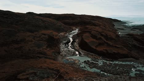 Aerial-push-in-on-Greenlandic-waterfall-by-the-icecap-and-point-660,-outside-Kangerlussuaq