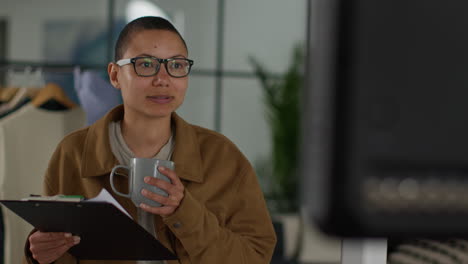 female film director watching performance of actors on monitor shooting movie or video in studio