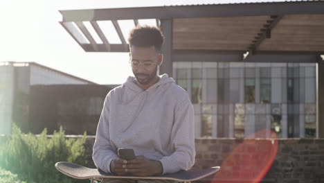 Ein-Junger-Skater-Benutzt-Sein-Mobiltelefon-Im-Sitzen