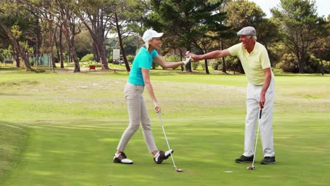 two happy golf players giving high five