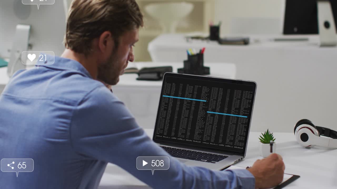 Developer writing on tablet while reviewing code and analyzing animating social metric icons