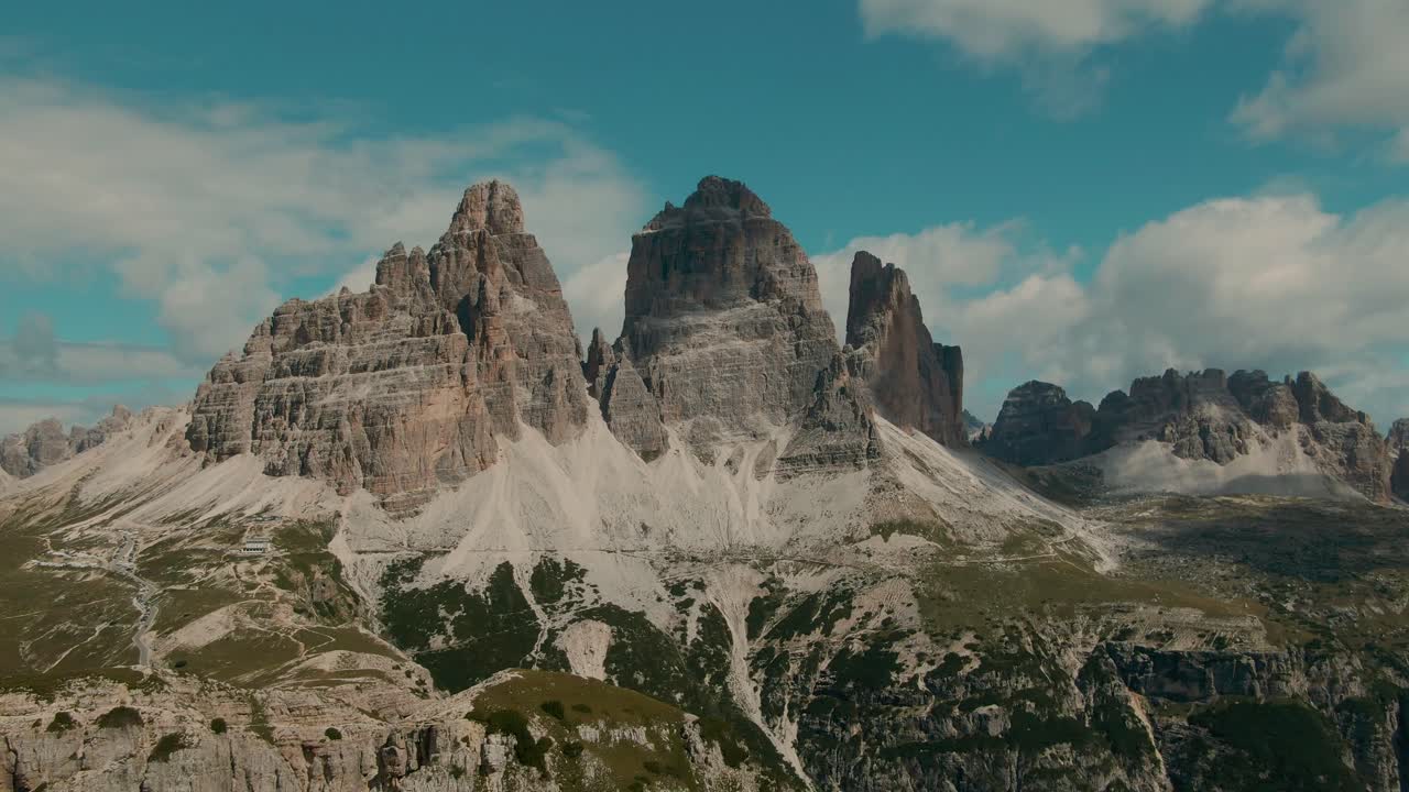 seguimiento de drones filmado con altas montañas rocosas empinadas y cielo parcialmente nublado en el fondo, vacaciones y vacaciones en los alpes paisaje majestuoso, grado de color cinematográfico