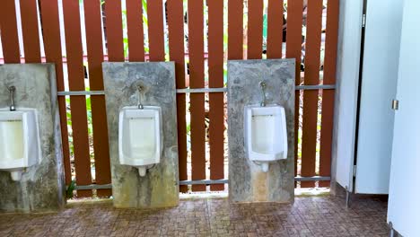 urinals in a public male restroom setting