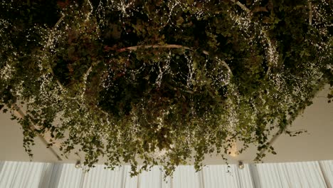 elegant ceiling decor of lush greenery intertwined with twinkling string lights, creating a magical atmosphere