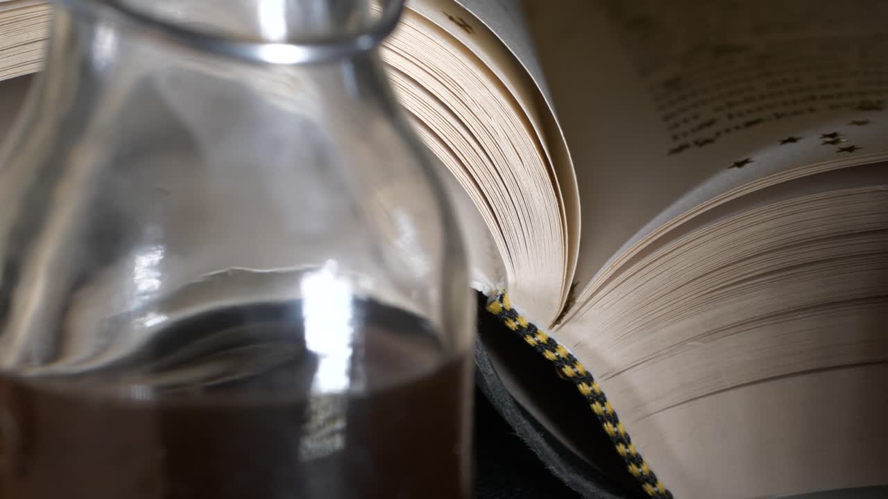 Book with defocused text, Slider panning past objects revealing main subject, close shot