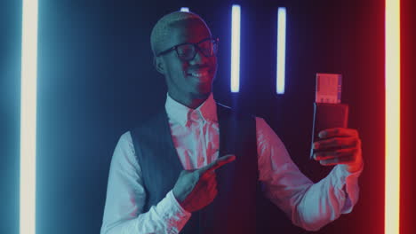man holding boarding pass in neon lights