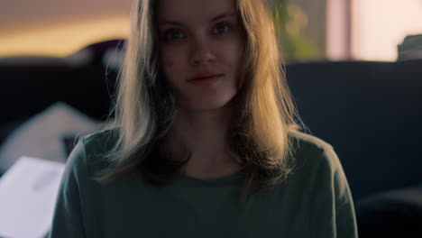 Cinematic-close-up-of-a-white-young-Woman-smiling-and-blowing-a-Kiss-straight-into-the-camera-during-a-Golden-Hour-at-Sunrise-in-her-apartment-in-slow-motion