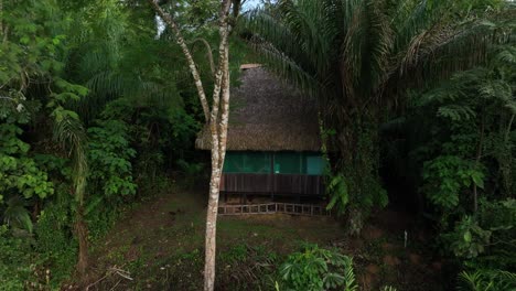 Aerial-drone-fly-view-of-Jungle-hut-in-the-Amazonia,-surrounded-by-trees,-rivers,-tropical-climate,-wild-animals,-rain-in-the-forest