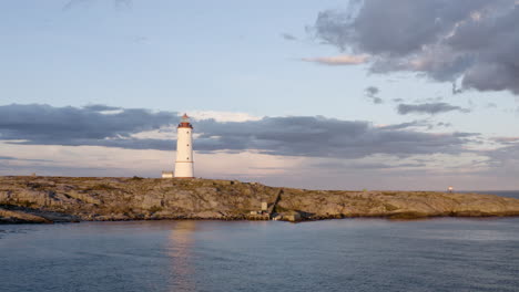 aerial view of lille torungen lighthouse in arendal, norway on a cloudy day - drone shot