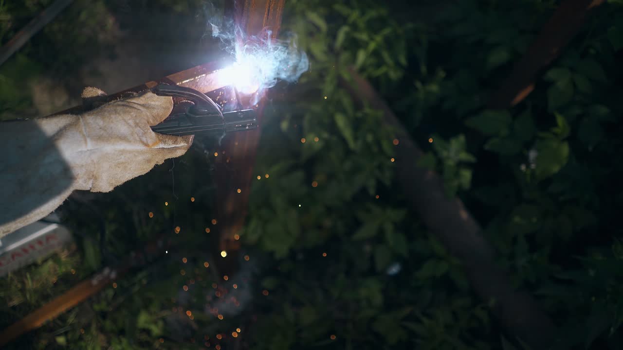 mano con herramienta de soldadura fija la valla cámara lenta vista de cerca