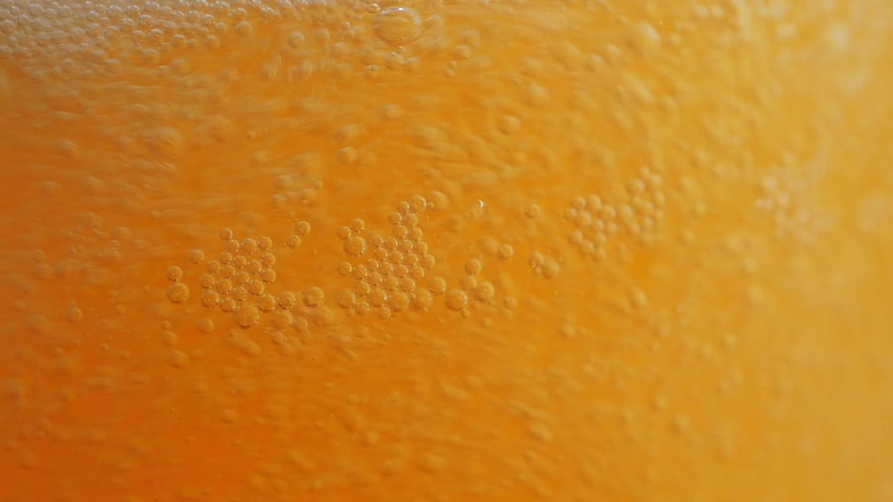 Amazing closeup of a beer glass that is being filled up with more beer