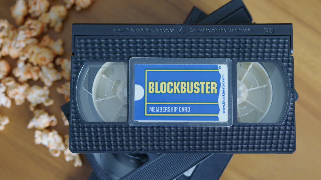 Close Up Pan Right Shot of a Blockbuster Membership Card with VHS Tapes and Popcorn