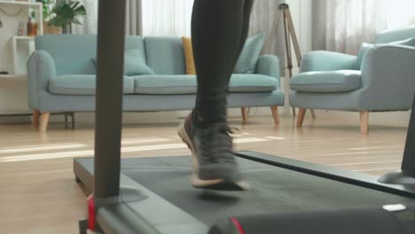 front view legs of asian woman running on a treadmill at home