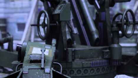 industrial artillery equipment showcased in a dimly lit workshop setting