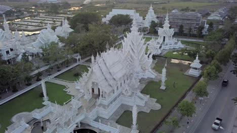thailand,chaing rai,white temple, drone footage of the white temple's whole complex with a perfect angle early in the morning. footage moves slowly from right to left turns around the temple complex.