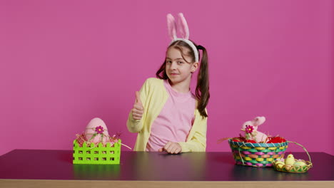 happy schoolgirl with bunny ears showing thumbs up sign