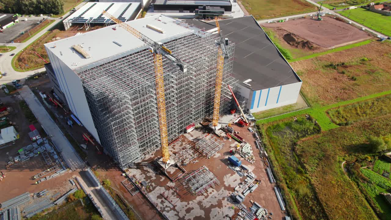 Revealing Drone Shot of Construction Site Building Large Steel Structure Against City Background