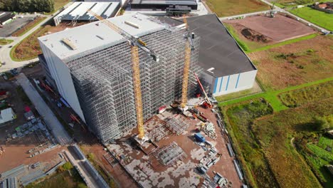 revealing drone shot of construction site building large steel structure against city background