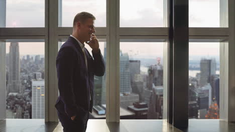 businessman talking on phone with city view