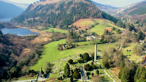 a steady drone shot 4oo feet above of the glendalough valley and graveyard