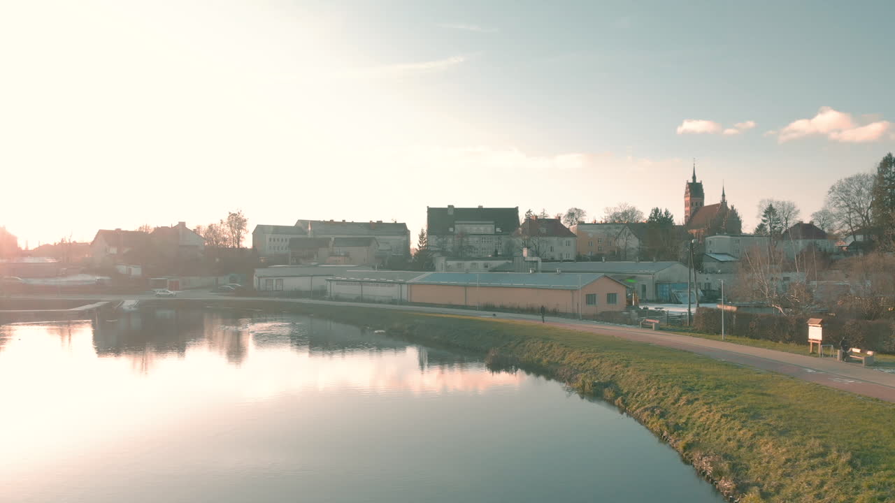 Hiking and cycling path over the pond, beautiful sun reflecting from the water, someone walking over the pond