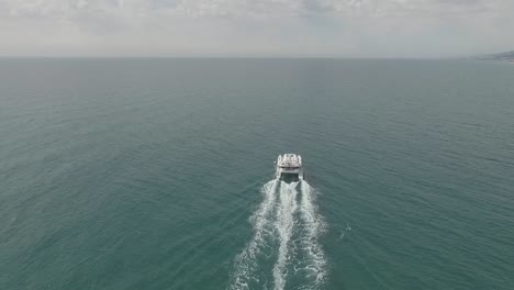 aerial view of luxurious big white yacht sailing in ocean leaving wake