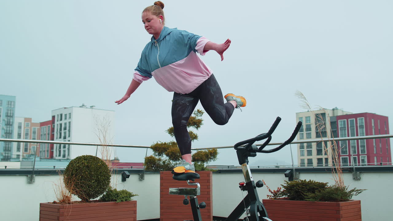 스피닝 스테이션 자전거에서 스 아크로바틱 트릭 운동을 하는 운동 여성