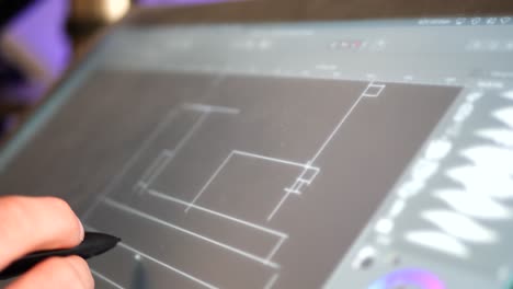 an architect drafting out blueprints or concept art for a building project on a digital graphic tablet in a design studio